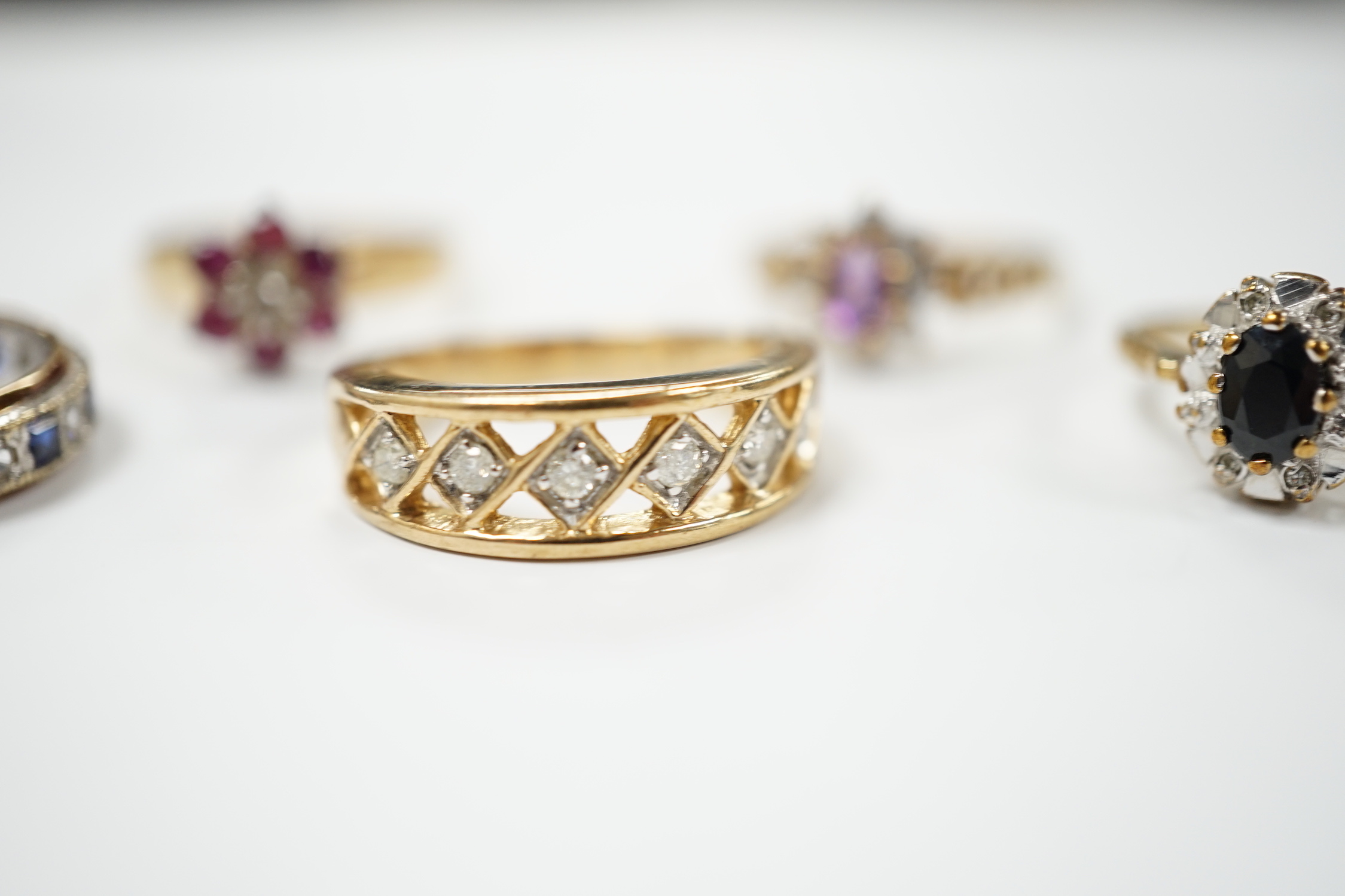 Five assorted modern 9ct gold and gem set dress rings including ruby and diamond cluster and six stone diamond set half hoop, gross weight 14.4 grams.